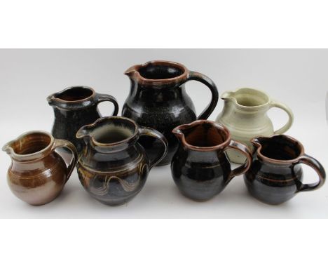 A collection of four Winchcombe pottery glazed stoneware jugs, of various sizes, and three other studio glazed jugs