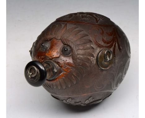 A 19TH CENTURY CARVED NUT FLASK with mask spout, hunting and musical trophy panels in relief, 14cm long