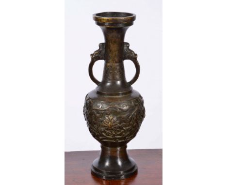 A 17TH CENTURY CHINESE BRONZE TWO HANDLED ALTAR VASE with stylised animal handles and raised foliate decoration, 42cm high