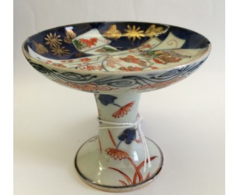 AN 18TH CENTURY JAPANESE PORCELAIN MINIATURE TAZZA with circular top, tapering stem and inverted base, cobalt blue and iron r
