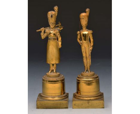 A PAIR OF 19TH CENTURY GILT BRONZE FIGURES of soldiers, one holding an axe, the other with cutlass on cylindrical plinths and