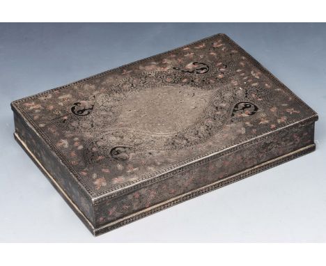 A MIDDLE EASTERN ENGRAVED SILVER PLAYING CARD BOX with stylistic scrolling motif, hinged rising lid and cedar lined interior,