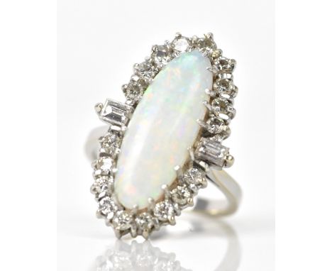 A white gold diamond and opal dress ring, having a central oval opal in a claw setting 7.8mm x 20.8mm 