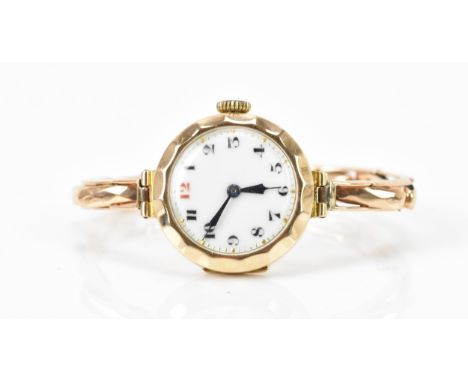 An early 20th century 9ct yellow gold ladies manual wind wristwatch, on a 9ct gold expanding bracelet, having a white enamel 