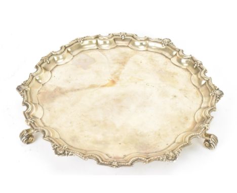 A George V silver salver by Adie Brothers, hallmarked Birmingham 1931, having a Chippendale rim with shell motifs and raised 