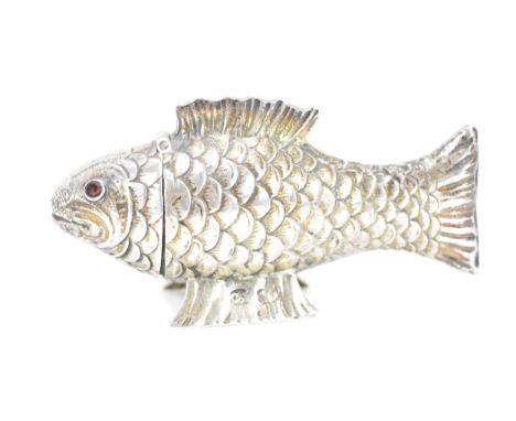 A late Victorian silver novelty lady's sewing etui, fashioned as an articulated fish, the hinged head inset with faceted cut 