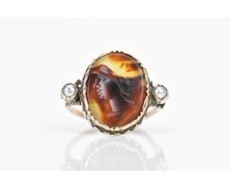 A 19th century yellow metal intaglio and pearl ring, carved with an oval male bust portrait 16.8mm x 12.4mm and flanked by tw