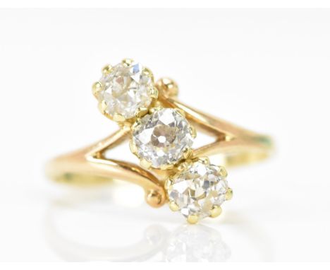 An 18 yellow gold diamond engagement ring, the three old cut diamonds each in a claw setting, the middle stone 4.7mm, flanked