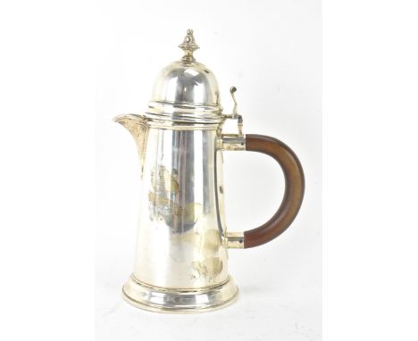 A George VI silver hot water jug by Wakely &amp; Wheeler, hallmarked London 1939, having a domed top lid with finial and scro