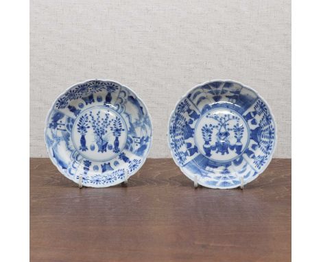 A pair of Chinese blue and white saucers,Kangxi (1662-1722), each of lobed circular form painted with vases of flowers in a r