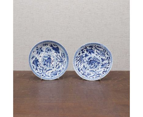 A pair of Chinese blue and white saucers,Kangxi (1662-1722), each with rounded sides rising from a circular foot, painted wit
