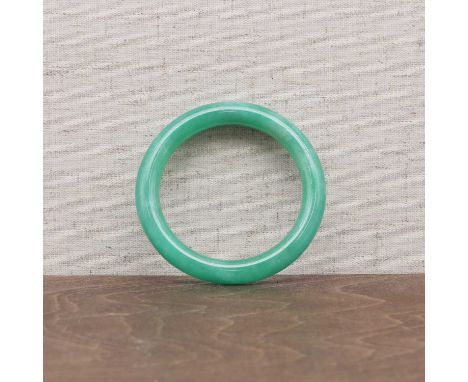 A Chinese jadeite bangle, 20th century, of circular cross-section form with a polished finish, medium green, vitreous lustre,