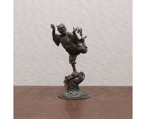 A Chinese brass figure,late Qing dynasty, of Kuixing, the God of Literature, standing with his right leg on the head of a hug