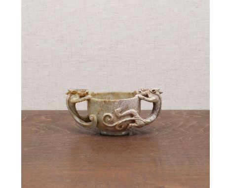 A Chinese jade two-handled cup,Ming dynasty (1368-1644), the rounded sides rising from a circular foot, flanked by two dragon