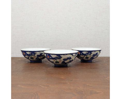 Three Chinese blue-ground white-enamelled bowls,Daoguang (1821-1850), each with rounded sides rising from a circular foot, pa