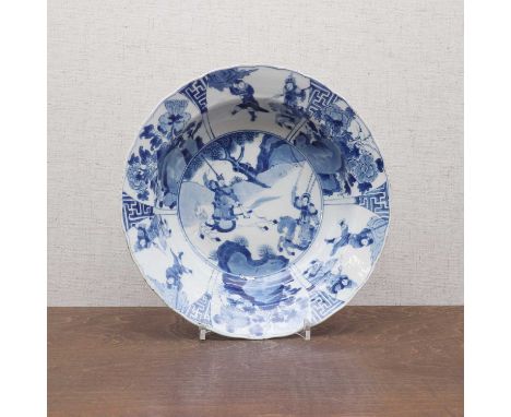 A Chinese blue and white soup bowl, Kangxi (1662-1722), the rounded sides rising from a circular foot to a broad, lobed, flar