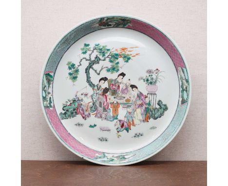 A Chinese famille rose charger,Guangxu (1875-1908), the rounded sides rising from a circular foot, painted with ladies playin