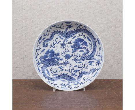 A Chinese blue and white plate,Republic period (1912-1949), the rounded sides rising from a circular foot, painted with two d
