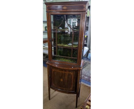 An Edwardian mahogany and boxwood cabinet having a glazed door above a bow fronted cupboard 191.5cm h x 67.5cm w Location:If 