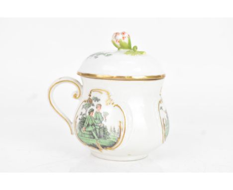 A 19th century Meissen lidded chocolate cup, the lid with a flower finial, scroll formed handle, three vignettes painted with