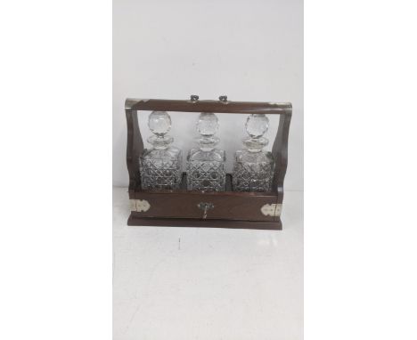A mid 20th century mahogany tantalus containing three crystal cut glass decantersLocation:If there is no condition report sho