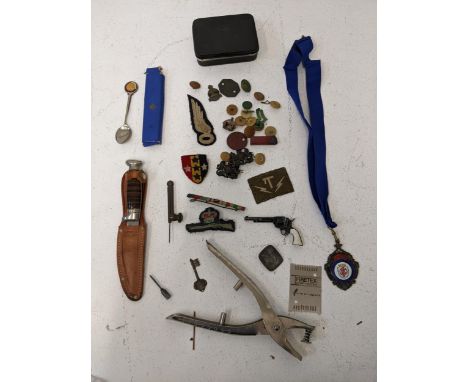 A group of collectables to include military badges and buttons, a Richards Tent brand Bowie style knife with leather scabbard