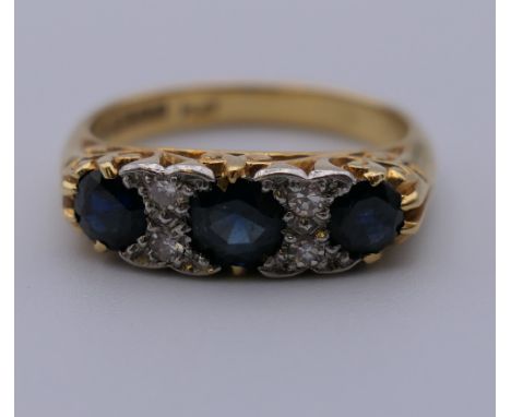 An 18 ct gold diamond and sapphire ring. Ring size K. 4.9 grammes total weight.