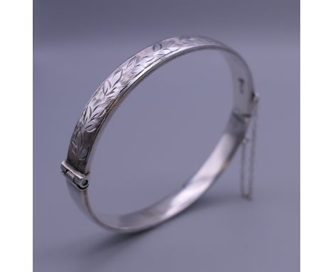 An embossed silver bangle form bracelet. 6.5 cm wide. 12.5 grammes.