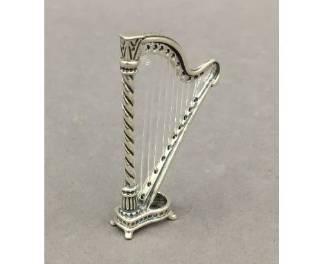 A small silver model of a harp. 5.5 cm high.