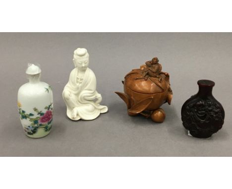 A small Chinese porcelain blanc de chine figure of Guanyin, two Chinese snuff bottles and a small Chinese wooden box and cove