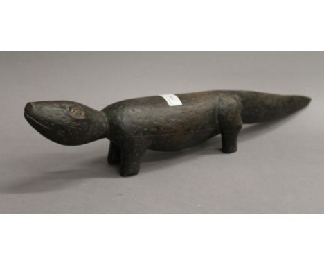 An Aboriginal carved wooden figure of a lizard. 54 cm long.