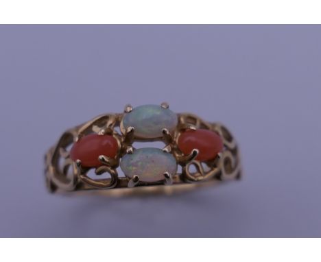 A 14 ct gold opal and coral ring. Ring size P. 2.5 grammes total weight.