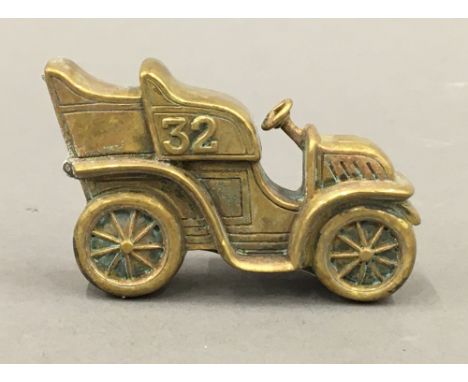 A brass vesta formed as a vintage car. 6.5 cm wide.