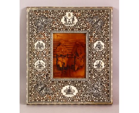 A 19TH CENTURY INDIAN CARVED AND PIERCED IVORY AND SANDALWOOD FRAME, with pen work decoration, containing an early photograph
