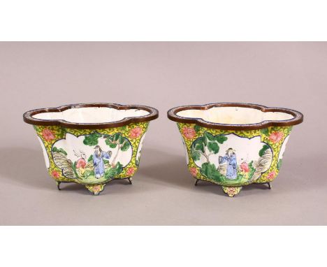 A PAIR OF CHINESE QIANLONG ENAMEL BOWLS, each decorated with a yellow ground and panels of figures in landscapes, the bases w