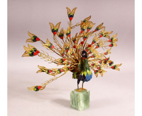 A DECORATIVE GILT METAL AND ENAMELLED MODEL OF A PEACOCK, plumage on full display, mounted on an onyx base, 25cm high.