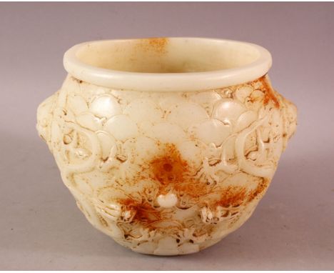A CARVED HETIAN JADE TWIN HANDLED BOWL, the body carved with dragons, 14cm high, 19cm diameter.