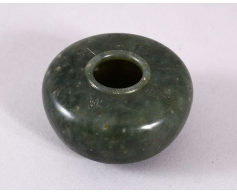 A CHINESE CARVED MOSS GREEN JADE INSCRIBED BUSH WASH, with five character inscription, 5.5cm diameter.