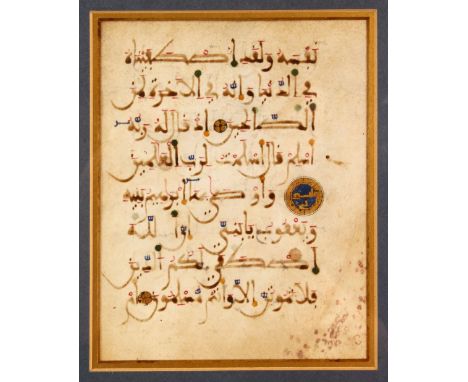 A FRAMED AND GLAZED KUFIC CALLIGRAPHIC MANUSCRIPT PAGE, double-sided, glazed on both sides, overall 31cm x 27cm.