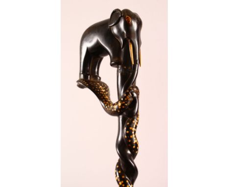 A GOOD CEYLONESE CARVED EBONY ELEPHANT &amp; SERPENT HANDLE WALKING STICK - carved handle in the form of an elephant upon ser