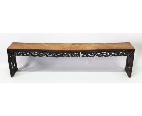 A CHINESE HARDWOOD BENCH SEAT with pierced and carved frieze and end supports, 187cm long, 27cm deep, 47cm high.