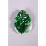A CHINESE CARVED JADEITE PENDANT, 6cm x 4cm.