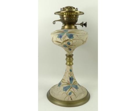 An Edwardian Hinks & Son ceramic and brass mounted oil lamp with duplex burner, the base painted against a stippled relief gr