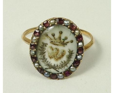 A George III period oval enamel betrothal ring decorated with a coronet, initial and wreath, in a surround of rubies and seed