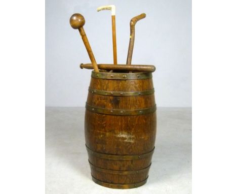 An oak and brass bound barrel converted to a stick stand, 63cm high, together with two walking sticks, a truncheon and a knob