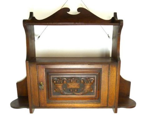 A Victorian mahogany wall shelf and small cupboard with a carved door, 70 by 15 by 56cm high.
