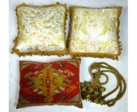 Two silk cushions, a tribal saddlebag cushion, 36 by 48cm, and a rope and tassel tie. (4)