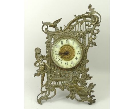 A Victorian cast brass easel clock, with cylinder movement, the frame formed as a harp with putti, the dial bearing Arabic nu