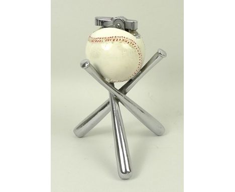 A 1920's novelty lighter in the form of a baseball raised on three bats, 11cm high.