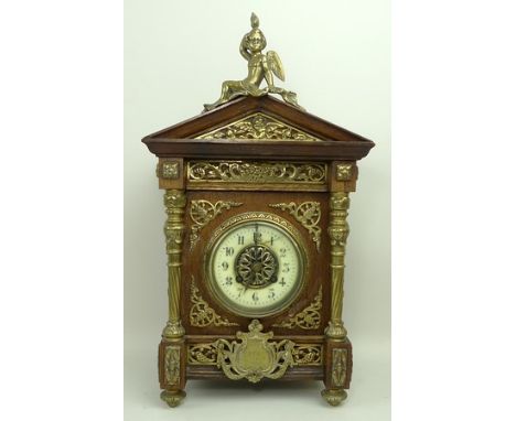 An oak cased mantel clock, early 20th century, of architectural form, with brass mounts in a Renaissance style, having masks 